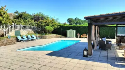 a swimming pool with chairs and a pavilion at As Seis Chemineas in San Xulián de Sales