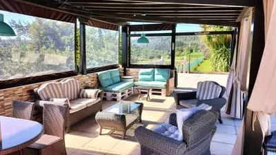 a screened in porch with chairs and a table at As Seis Chemineas in San Xulián de Sales