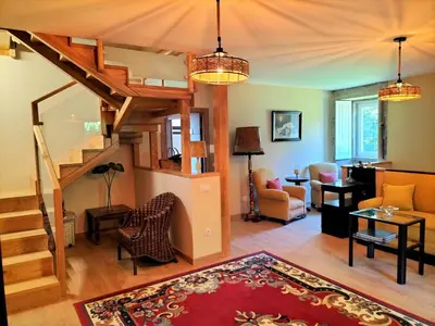 a living room with a spiral staircase and a living room at As Seis Chemineas in San Xulián de Sales