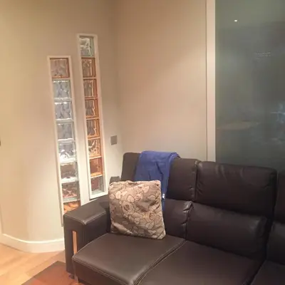 a living room with a leather couch and a window at Bierzo centro in Ponferrada