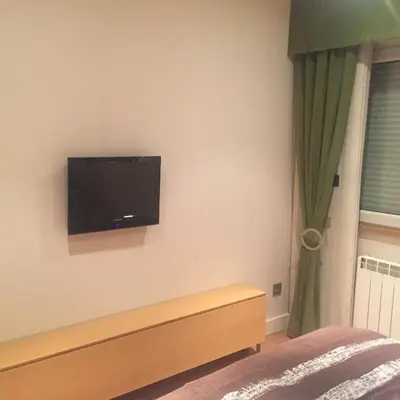 a bedroom with a flat screen tv on the wall at Bierzo centro in Ponferrada