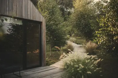 a wooden walkway next to a building with a glass door at MU_MORADAS NO ULLA in Teo