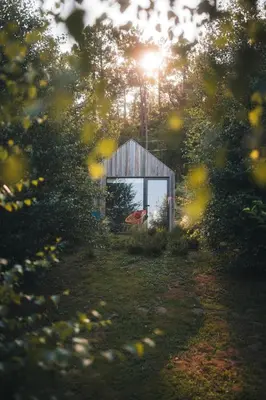 a smallshed in the middle of a field with the sun shining at MU_MORADAS NO ULLA in Teo