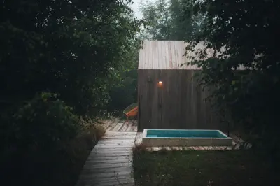 a swimming pool in front of a wooden fence at MU_MORADAS NO ULLA in Teo