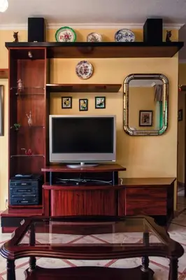 a living room with a television on a wooden entertainment center at SAN CIPRIAN 