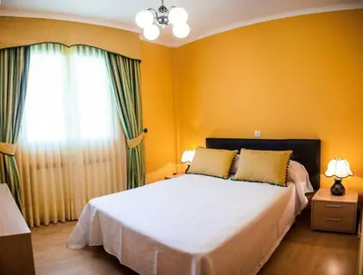 a bedroom with a bed with yellow walls and a window at SAN CIPRIAN 