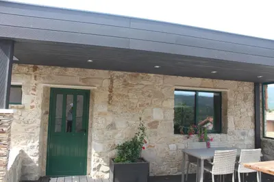 a building with a green door and a table and chairs at Casa Spa en montaña in Pontevedra