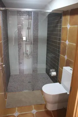 a bathroom with a toilet and a glass shower at Casa Spa en montaña in Pontevedra