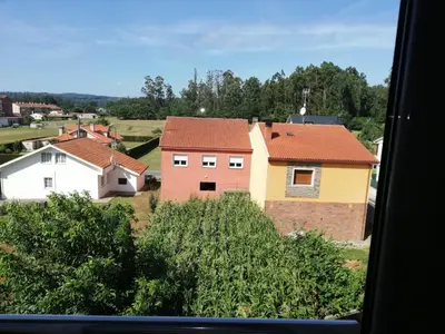a view of a group of houses from a window at Pedrouzo Suites in O Pedrouzo