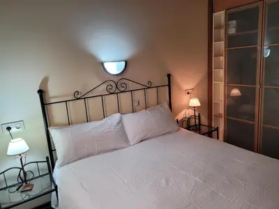 a bedroom with a white bed with a light above it at El Relax de Sanabria in Trefacio