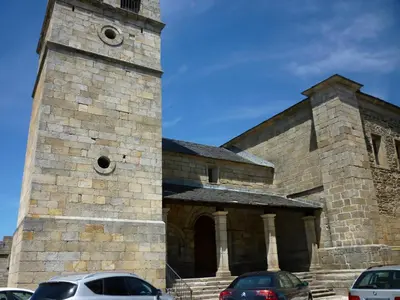 a church with cars parked in front of it at El Relax de Sanabria in Trefacio