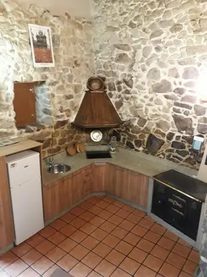 a kitchen with a sink and a clock on a stone wall at Loft Corte de Fora in Ourense