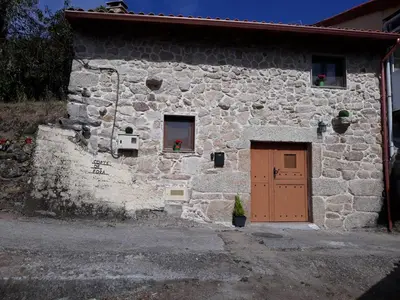 a stone building with a brown door and a window at Loft Corte de Fora in Ourense
