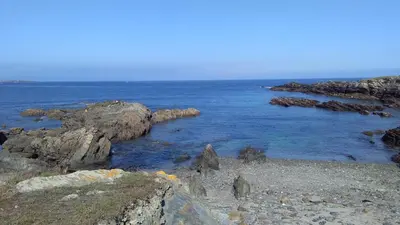 a group of rocks in the water near the ocean at A Minguxaina in Ribadeo