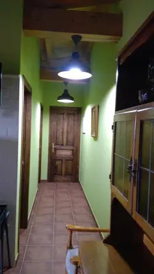 an empty hallway with green walls and a wooden door at A Minguxaina in Ribadeo
