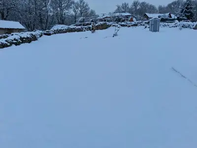 a snow covered yard with a house in the background at A Brava in Sas de Penelas
