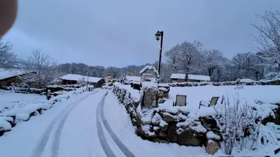 a snow covered road with a snow covered yard at A Brava in Sas de Penelas