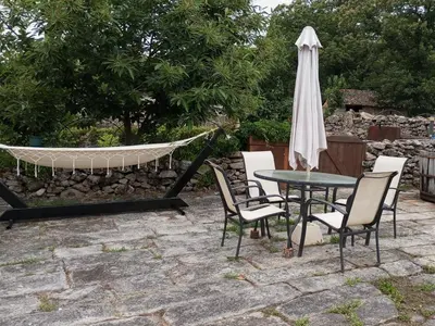 a patio with a table and a hammock and an umbrella at A Brava in Sas de Penelas