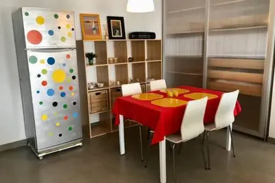 a dining room with a red table and a refrigerator at La Casa de Antón in Tineo