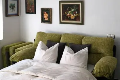 a bedroom with a bed and a green couch at La Casa de Antón in Tineo