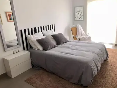 a bedroom with a bed with a mirror and a chair at La Casa de Antón in Tineo
