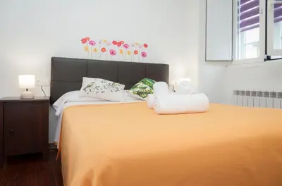 a bedroom with a large bed with orange sheets at Apartamento Algalia Catedral in Santiago de Compostela