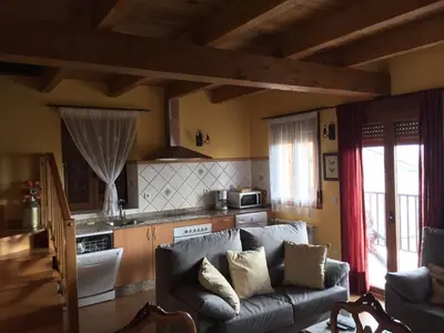 a living room with a couch and a kitchen at El Mirador del Bierzo in Tedejo
