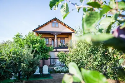 a house with a balcony and chairs in front of it at El Mirador del Bierzo in Tedejo