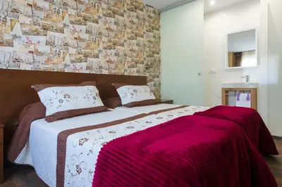 a bedroom with a large bed with a pink blanket at Pension ARCA in O Pedrouzo