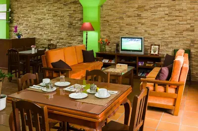 a living room with a table and chairs and a couch at Pension ARCA in O Pedrouzo