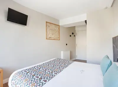a bedroom with a bed and a tv on the wall at PR 25 de Julio in Santiago de Compostela