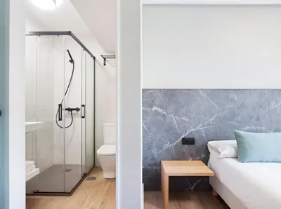 a bathroom with a shower and a bedroom with a bed at PR 25 de Julio in Santiago de Compostela
