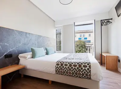 a bedroom with a bed and a large window at PR 25 de Julio in Santiago de Compostela