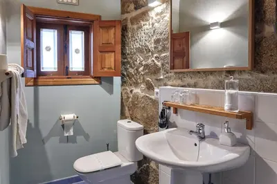a bathroom with a sink and a toilet and a mirror at Casa de Turismo Rural Sabariz in Sabariz