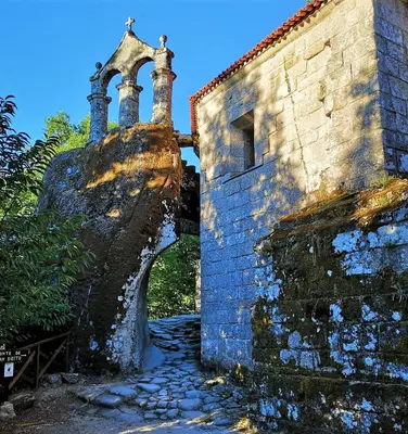 an old brick building with an archway on the side at La Casa de las Rocas - En la Ribeira Sacra in Nogueira de Ramuin