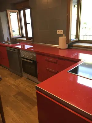 a kitchen with red counters and a red counter top at Narcea Turismo Real in Cangas del Narcea