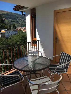 a table and chairs on a balcony with a view at Narcea Turismo Real in Cangas del Narcea