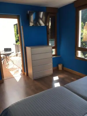 a bedroom with a bed and a tv on a blue wall at Narcea Turismo Real in Cangas del Narcea