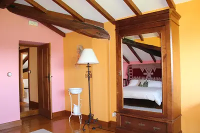 a bedroom with a bed with a large mirror at Rectoral de Anllo in Sober