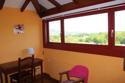 a room with a desk and two chairs and a window at Rectoral de Anllo in Sober