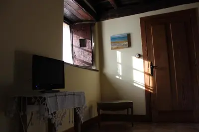 a room with a television on a table and a window at Rectoral de Anllo in Sober