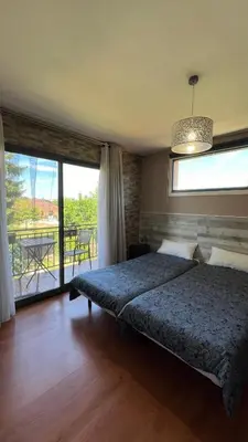 a bedroom with a bed and a large window at Twin Pines Camino Norte in Arzúa