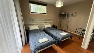 a bedroom with two beds and a window at Twin Pines Camino Norte in Arzúa
