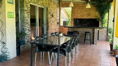 a patio with a black table and chairs and a fireplace at Twin Pines Camino Norte in Arzúa