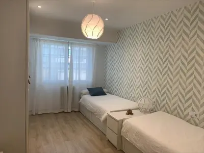 a bedroom with two beds and a pendant light at Apartamento Barrio San Pedro in Santiago de Compostela