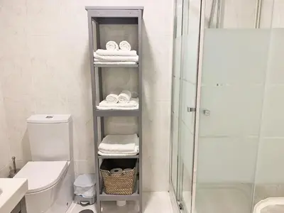 a bathroom with a shower and a shelf with towels at Apartamento Barrio San Pedro in Santiago de Compostela