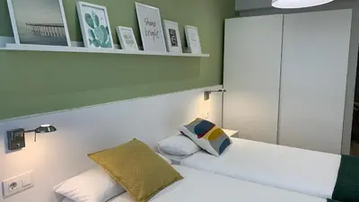 a bedroom with two white beds and a mirror at Apartamento Barrio San Pedro in Santiago de Compostela