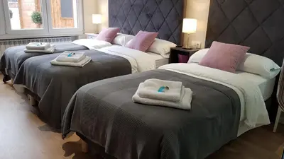 two beds with towels on top of them in a room at PortoHouse in Portomarin