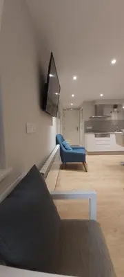 a living room with a couch and a blue chair at PortoHouse in Portomarin