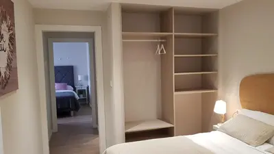 a bedroom with a bed and a closet with shelves at PortoHouse in Portomarin